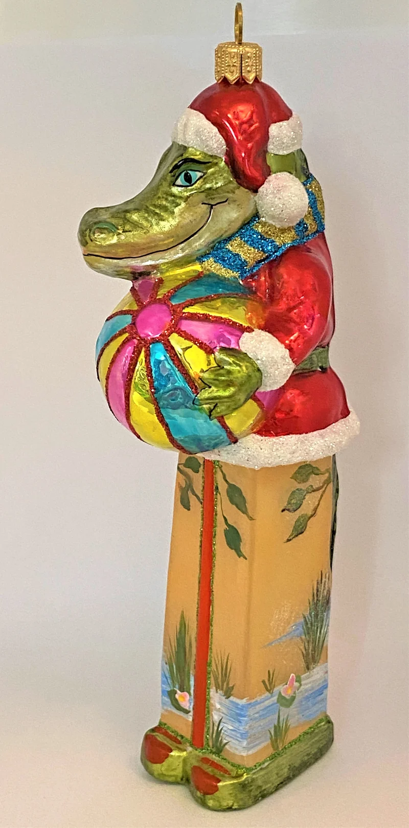 Krokodil im Santa-Kostüm spielt mit dem Ball