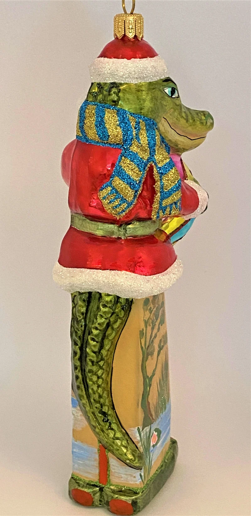Krokodil im Santa-Kostüm spielt mit dem Ball