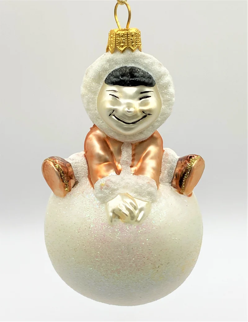 Inuit Junge turnt auf einem Schneeball