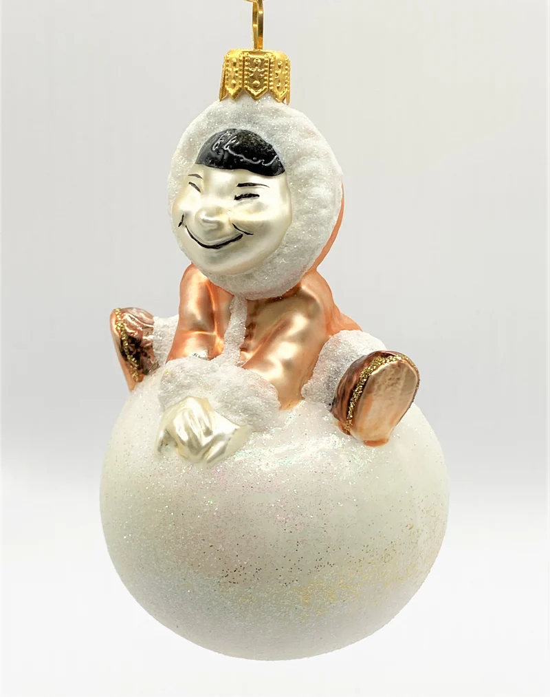 Inuit Junge turnt auf einem Schneeball