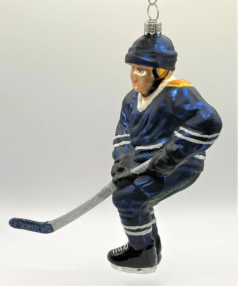 Schweizer Eishockey Spieler in dunkelblauem Trikot mit gelbem Streifen
