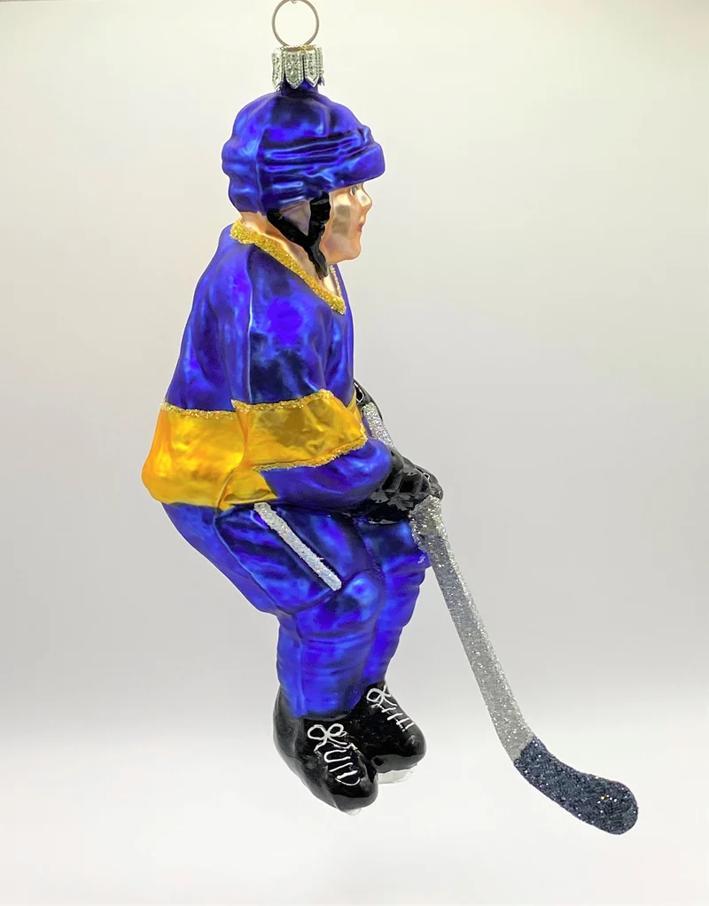 Schweizer Eishockey Spieler in blauem Trikot mit gelben Streifen