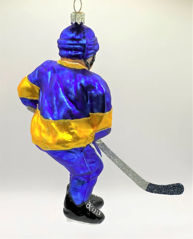 Schweizer Eishockey Spieler in blauem Trikot mit gelben Streifen