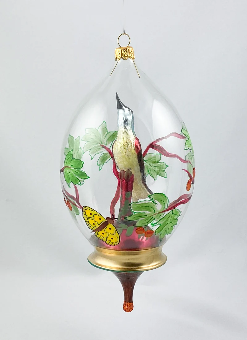 Singvogel in Kugel mit Schmetterling und Rankendekor