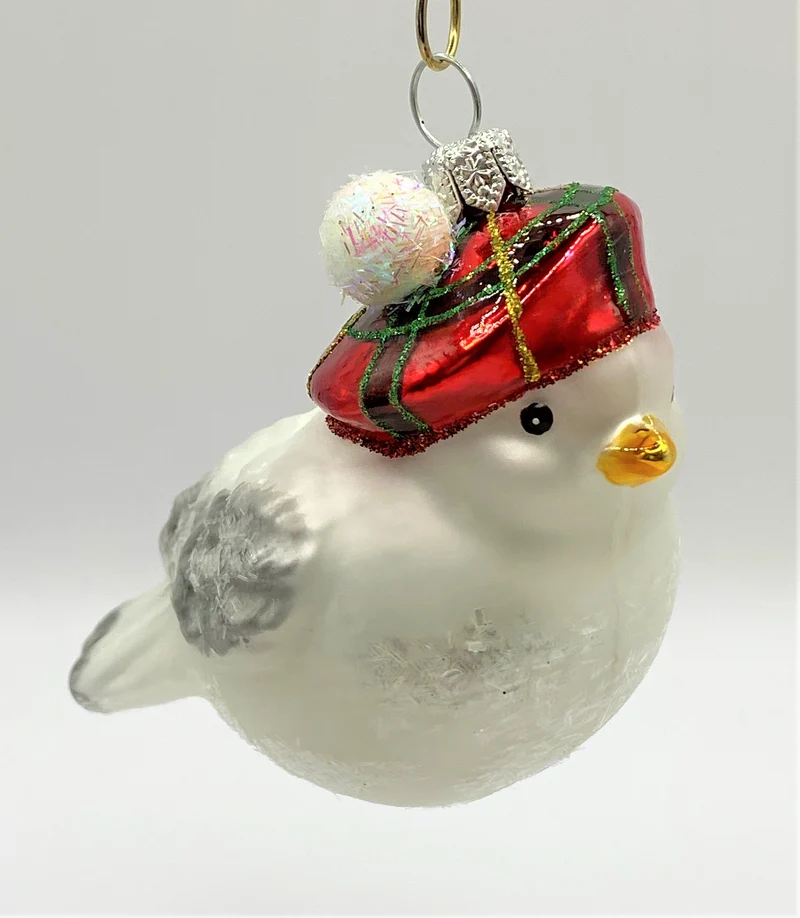 Weisses Wintervögelchen mit karierter Bommel-Mütze