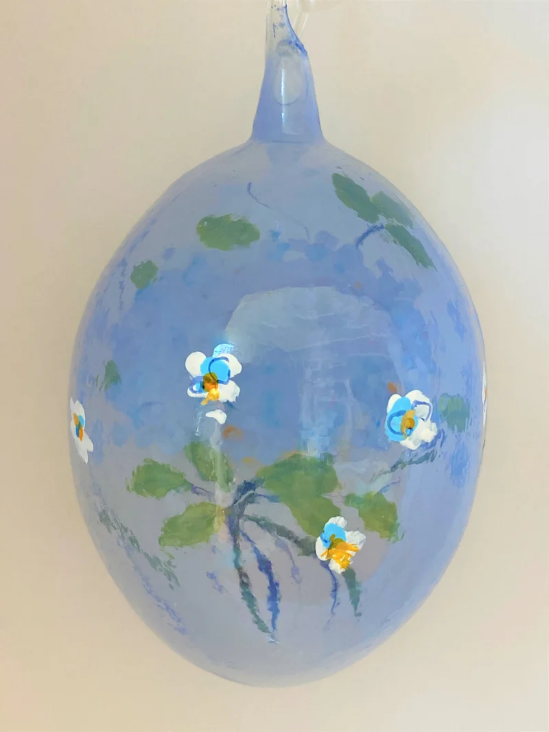 Hellblaues Osterei mit Blütenstrauss