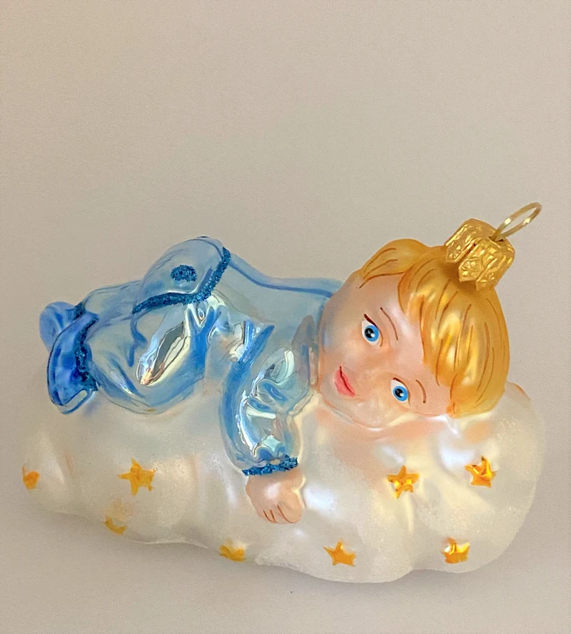 Kleiner Junge im hellblauen Pyjama schwebt auf der Sternchen-Wolke