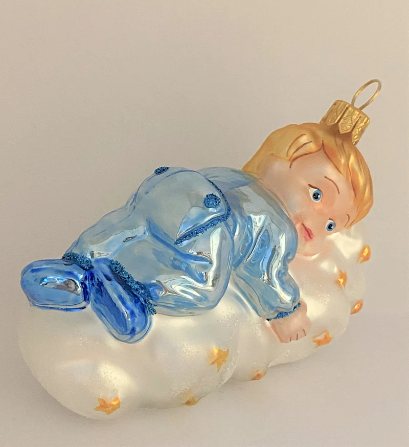 Kleiner Junge im hellblauen Pyjama schwebt auf der Sternchen-Wolke