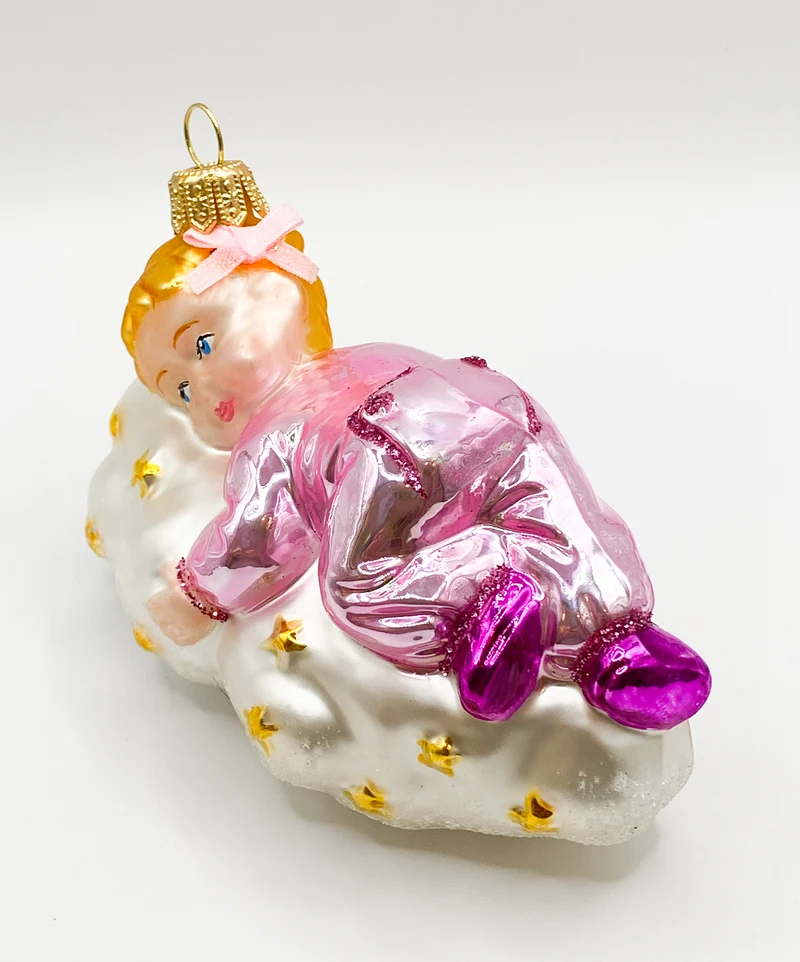 Kleines Mädchen im rosa Pyjama schwebt auf der Sternchen-Wolke
