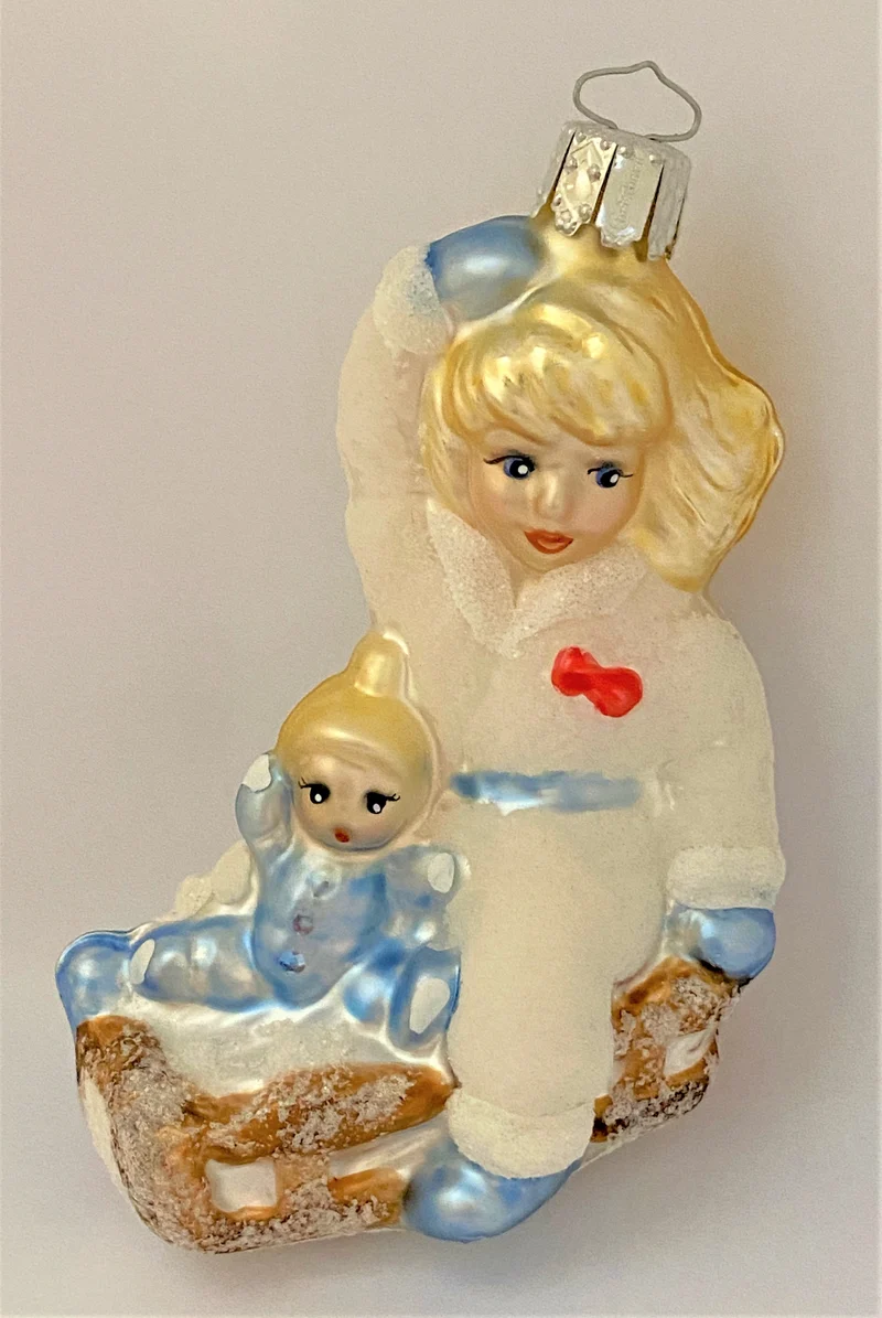 Mädchen fährt Schlitten mit der Puppe
