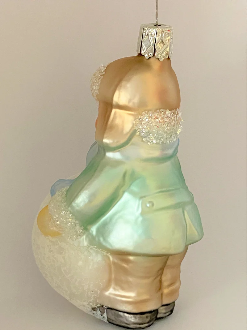 Kleiner Junge mit Wintermütze macht einen riesigen Schneeball, pastell