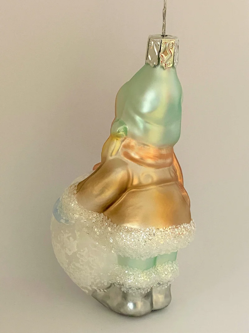 Kleines Mädchen mit Wintermütze macht einen riesigen Schneeball, pastell