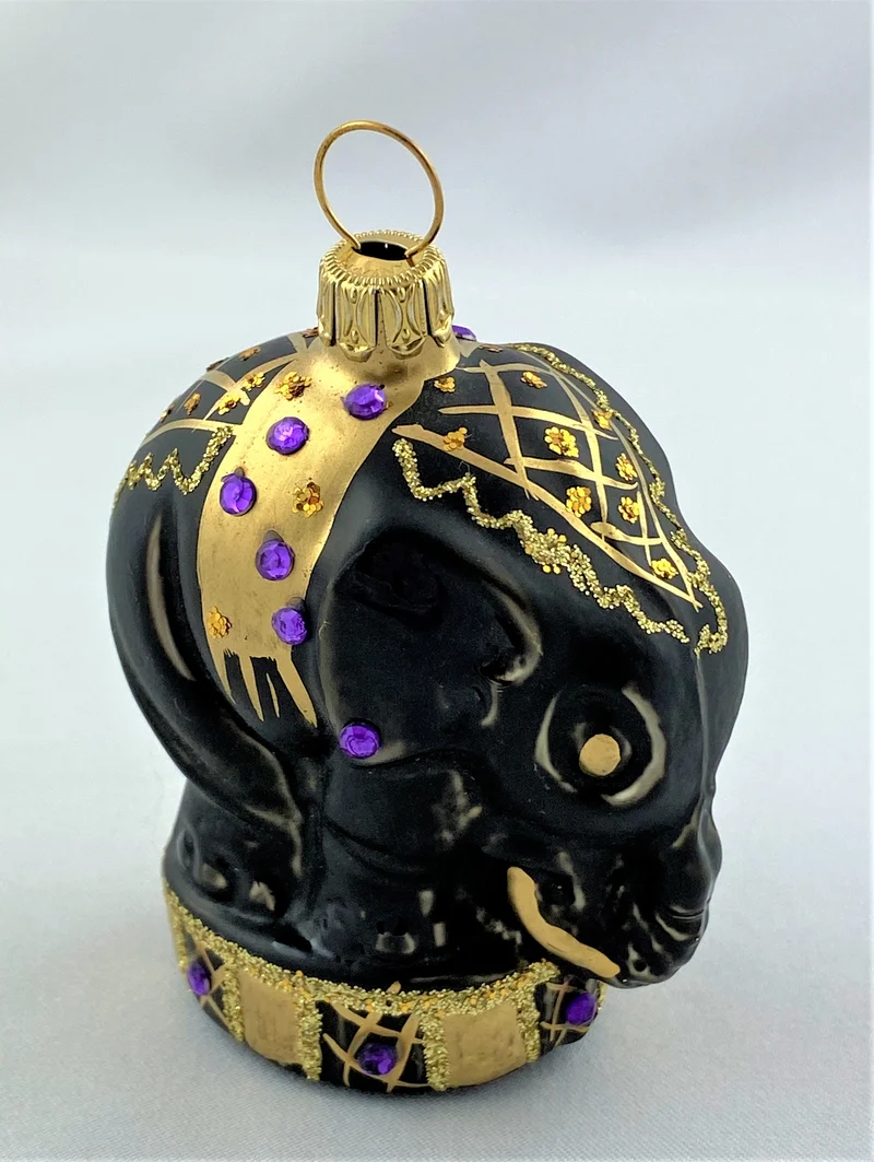 Schwarzer Zirkuselefant auf Podest mit violetten Glitzersteinchen