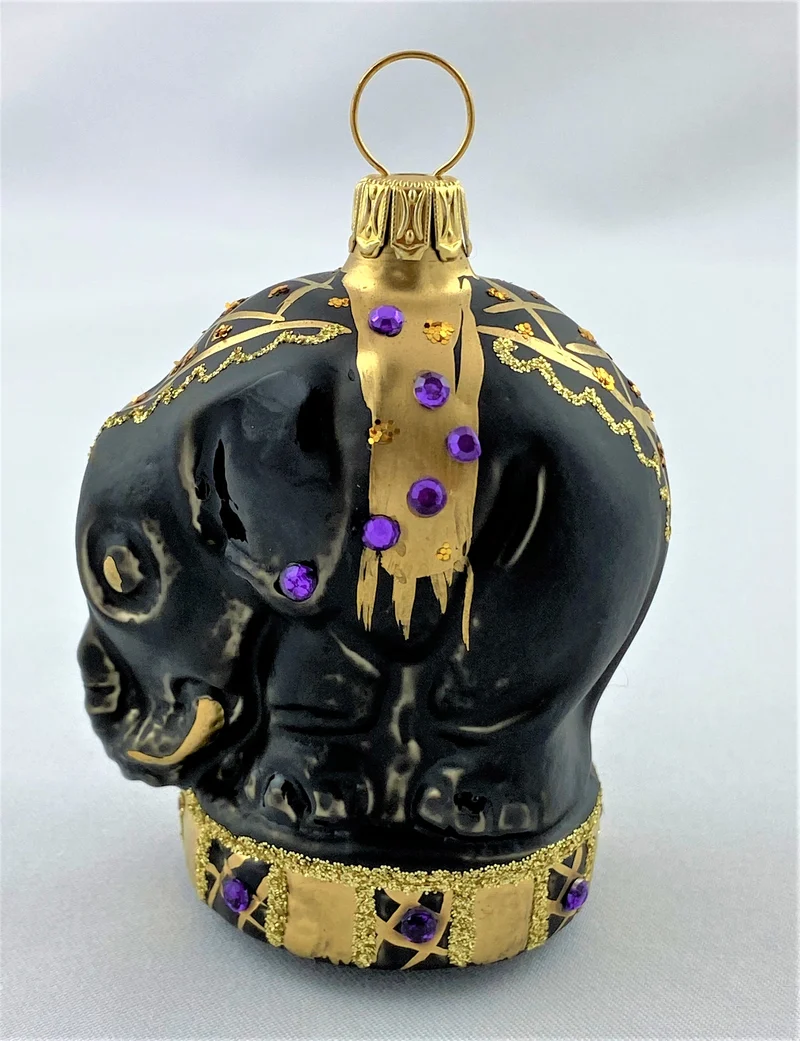 Schwarzer Zirkuselefant auf Podest mit violetten Glitzersteinchen