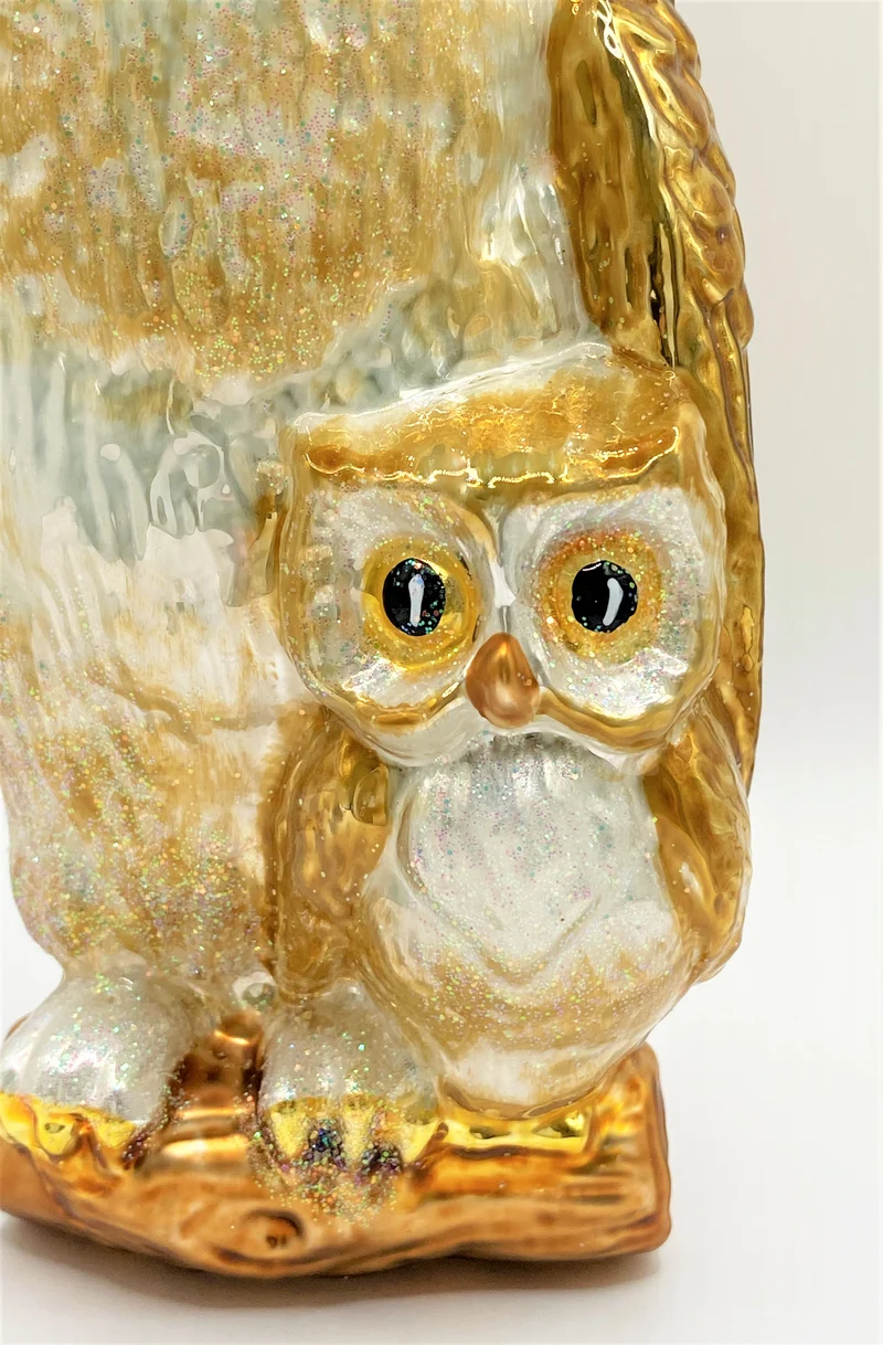 Die Eule hält schützend den Flügel über ihr Junges