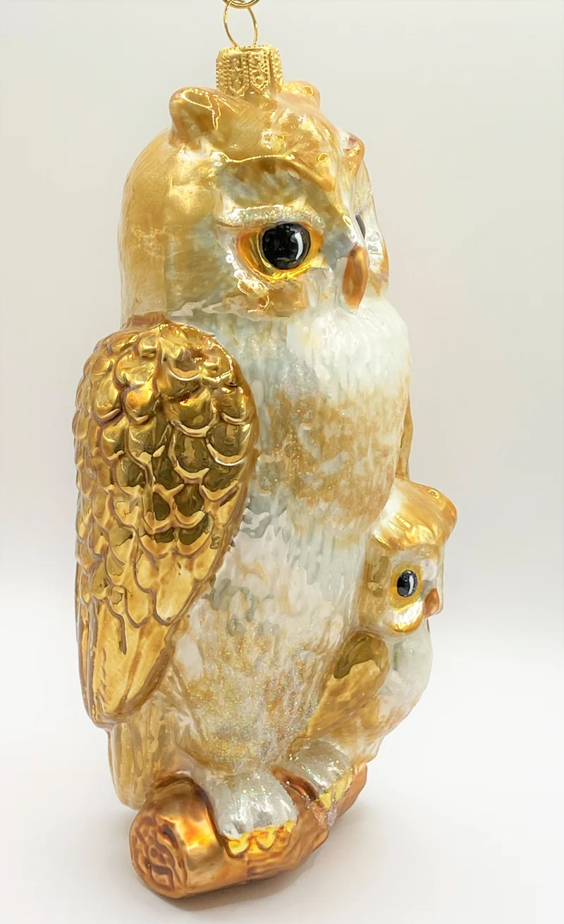 Die Eule hält schützend den Flügel über ihr Junges