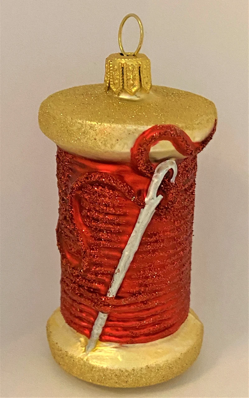 Rote Fadenspule mit Nähnadel