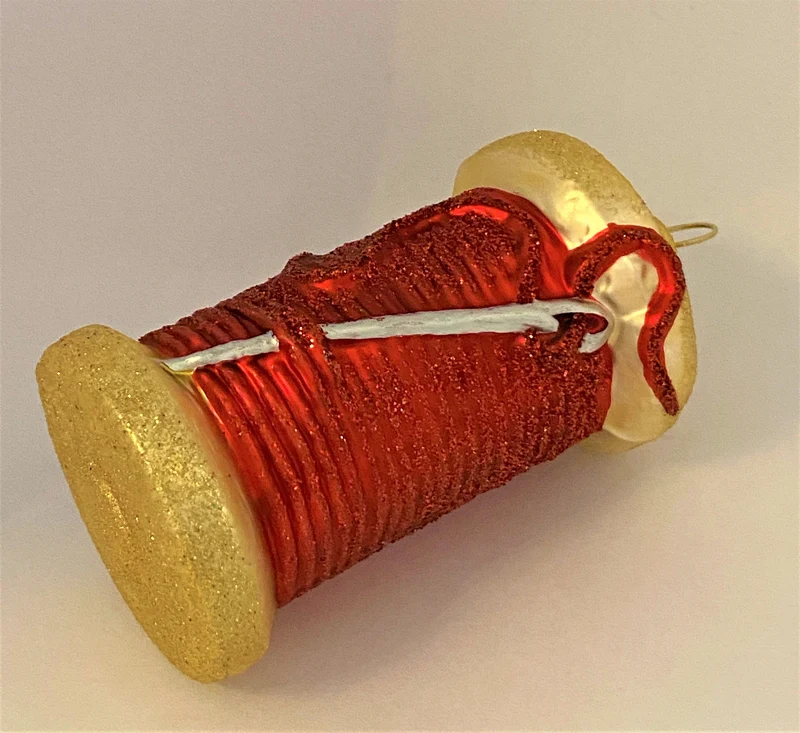Rote Fadenspule mit Nähnadel