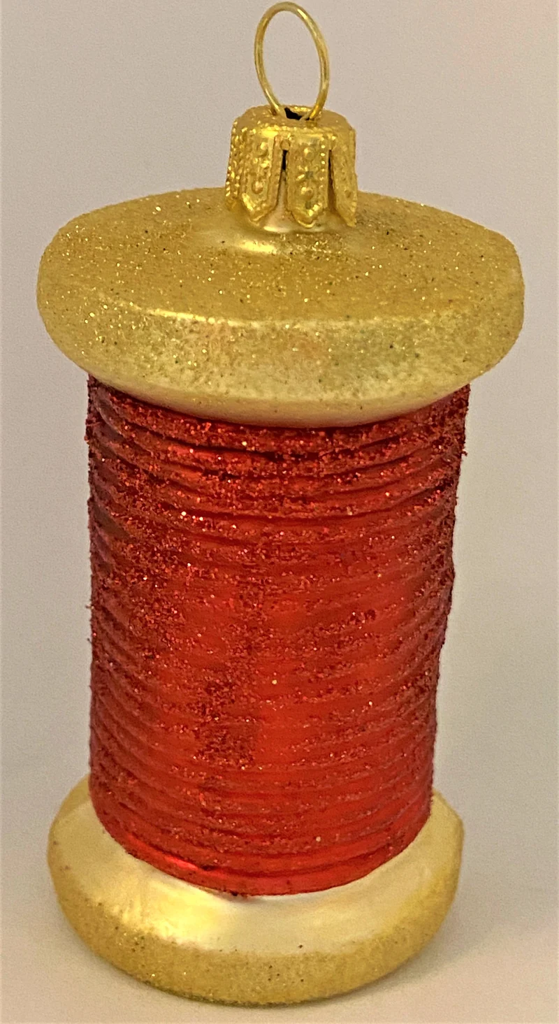 Rote Fadenspule mit Nähnadel
