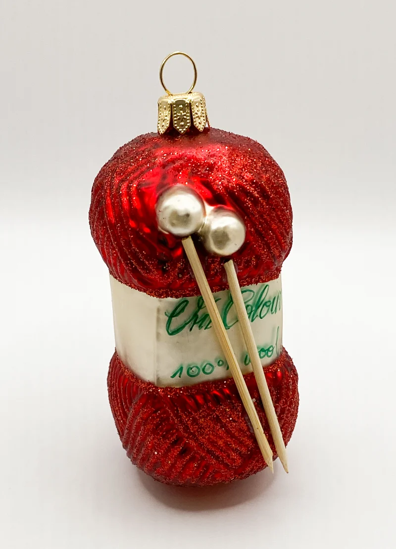 Roter Wollknäuel mit Stricknadeln
