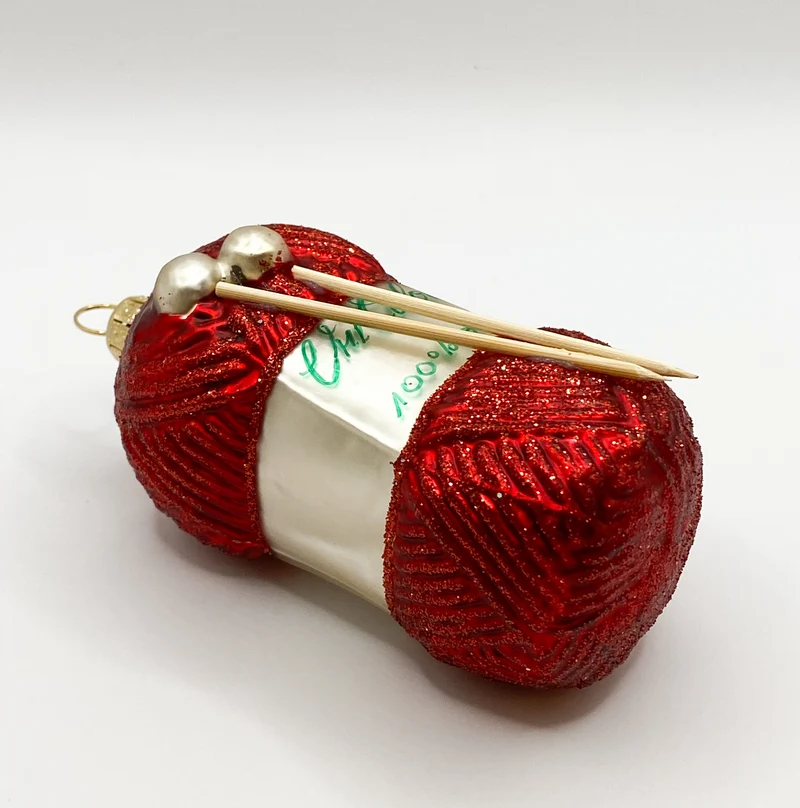 Roter Wollknäuel mit Stricknadeln