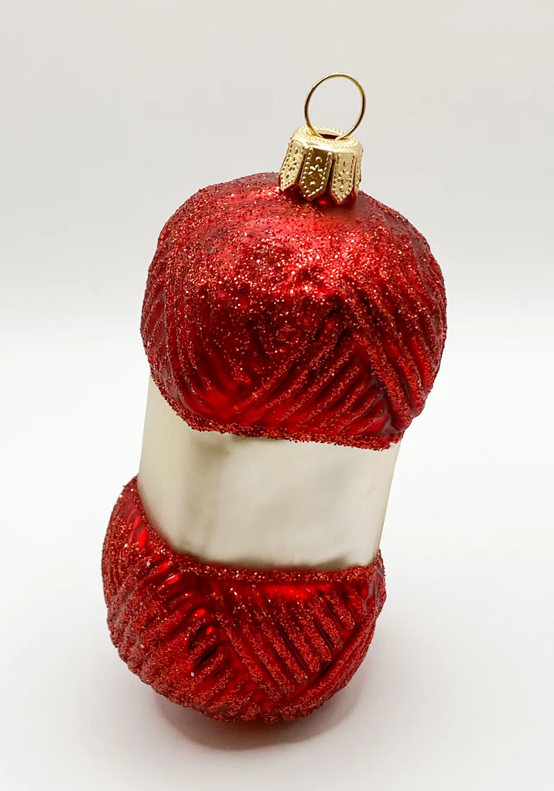 Roter Wollknäuel mit Stricknadeln
