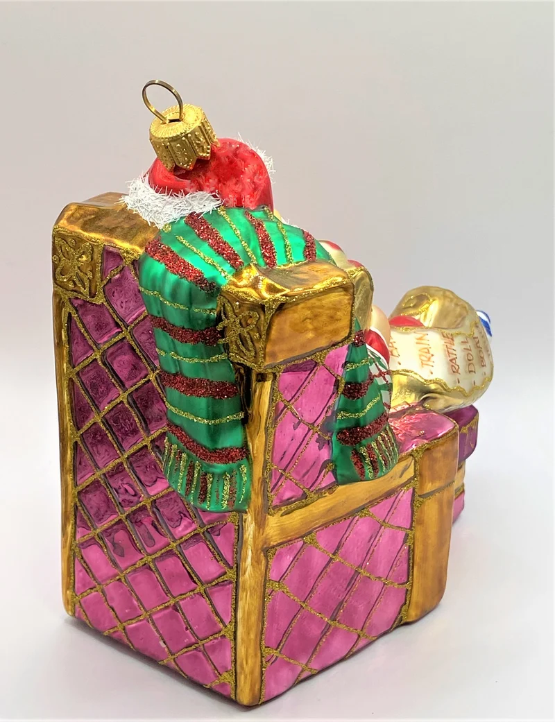 Santa Claus sitzt bequem im Sessel und studiert die Geschenke-Liste