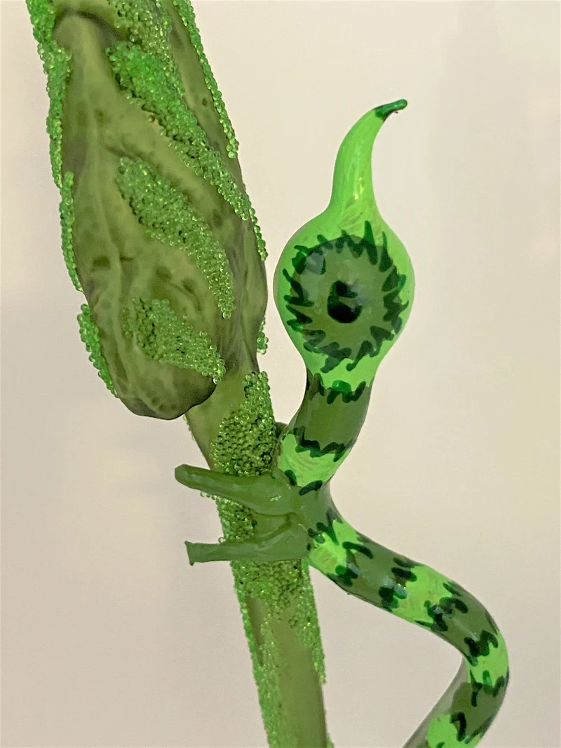 Grüne Raupe krabbelt am Blatt hoch