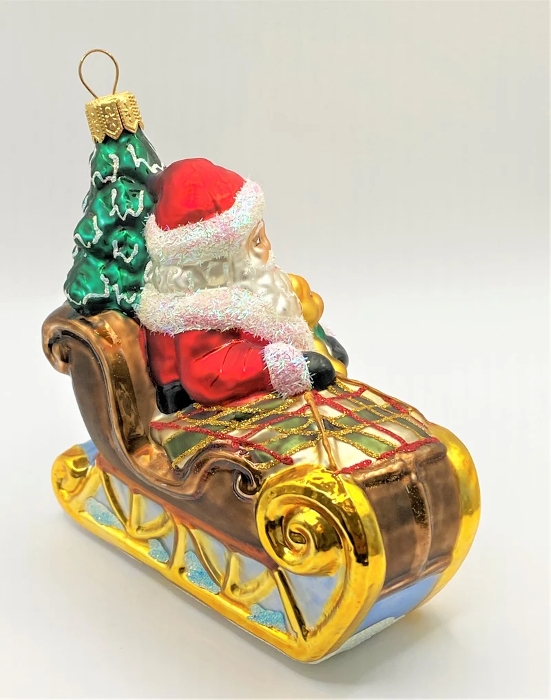 Weihnachtsmann bringt den Christbaum mit dem Schlitten, karierte Decke