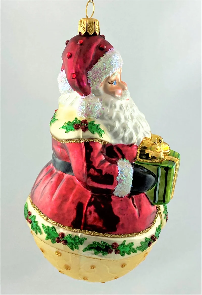 Weihnachtsmann auf Kugel und Ilex-Dekor am Mantel