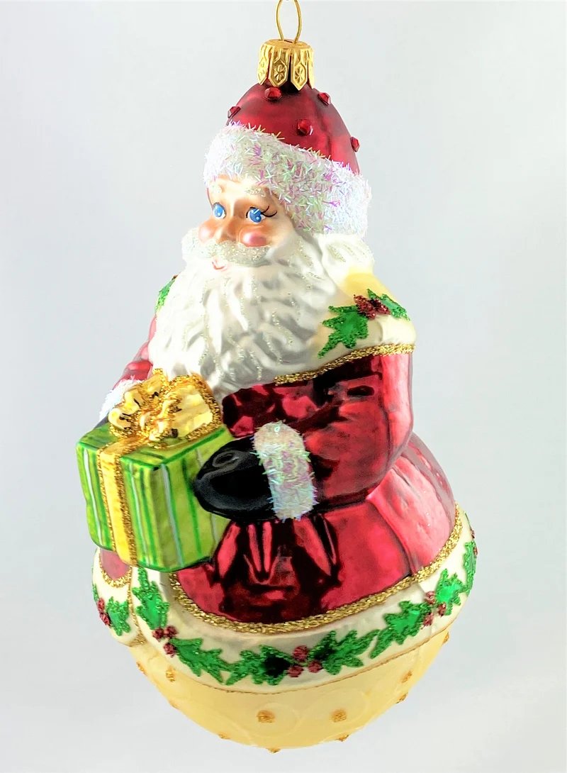 Weihnachtsmann auf Kugel und Ilex-Dekor am Mantel