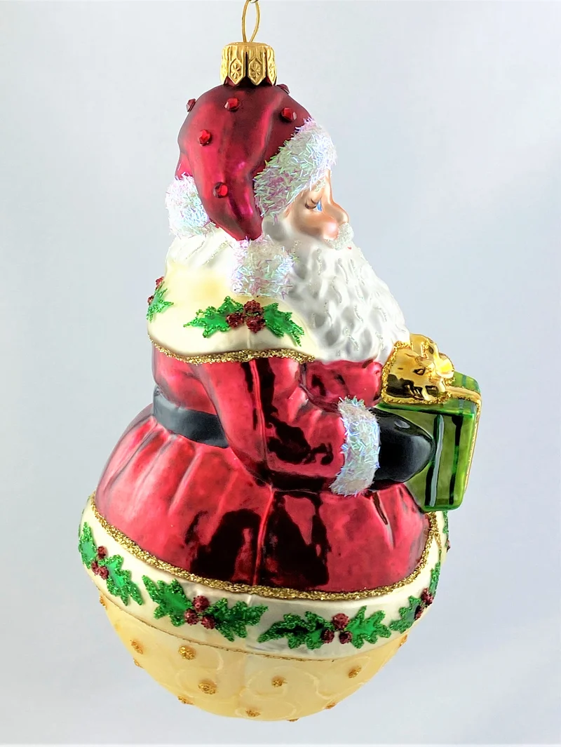 Weihnachtsmann auf Kugel und Ilex-Dekor am Mantel