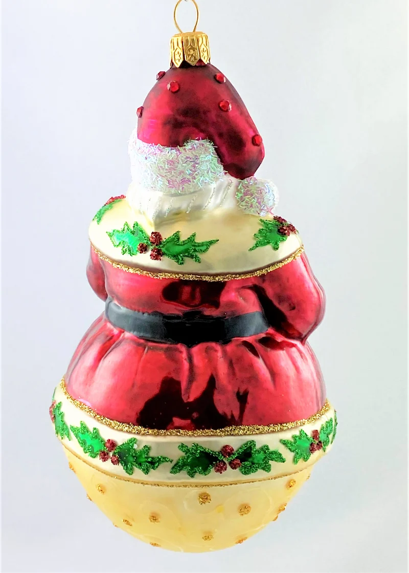 Weihnachtsmann auf Kugel und Ilex-Dekor am Mantel