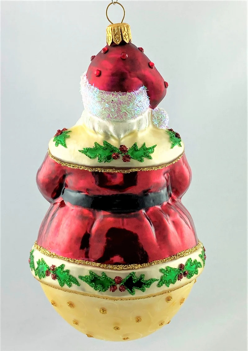 Weihnachtsmann auf Kugel und Ilex-Dekor am Mantel