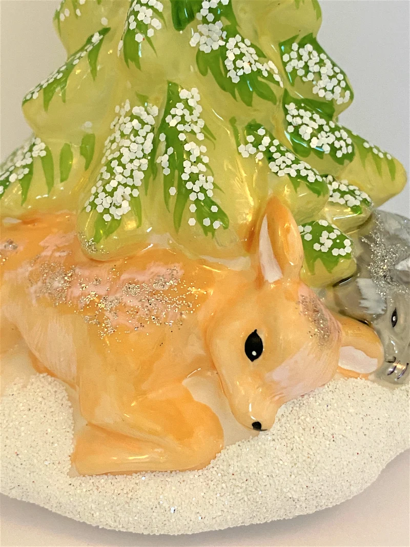 Reh und Hase schlafen unter der verschneiten Tanne