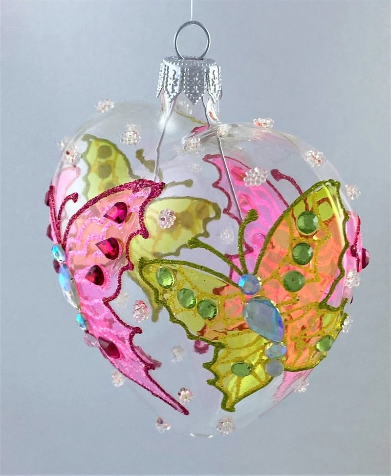 Transparentes Herz mit grünem und rosa Schmetterling