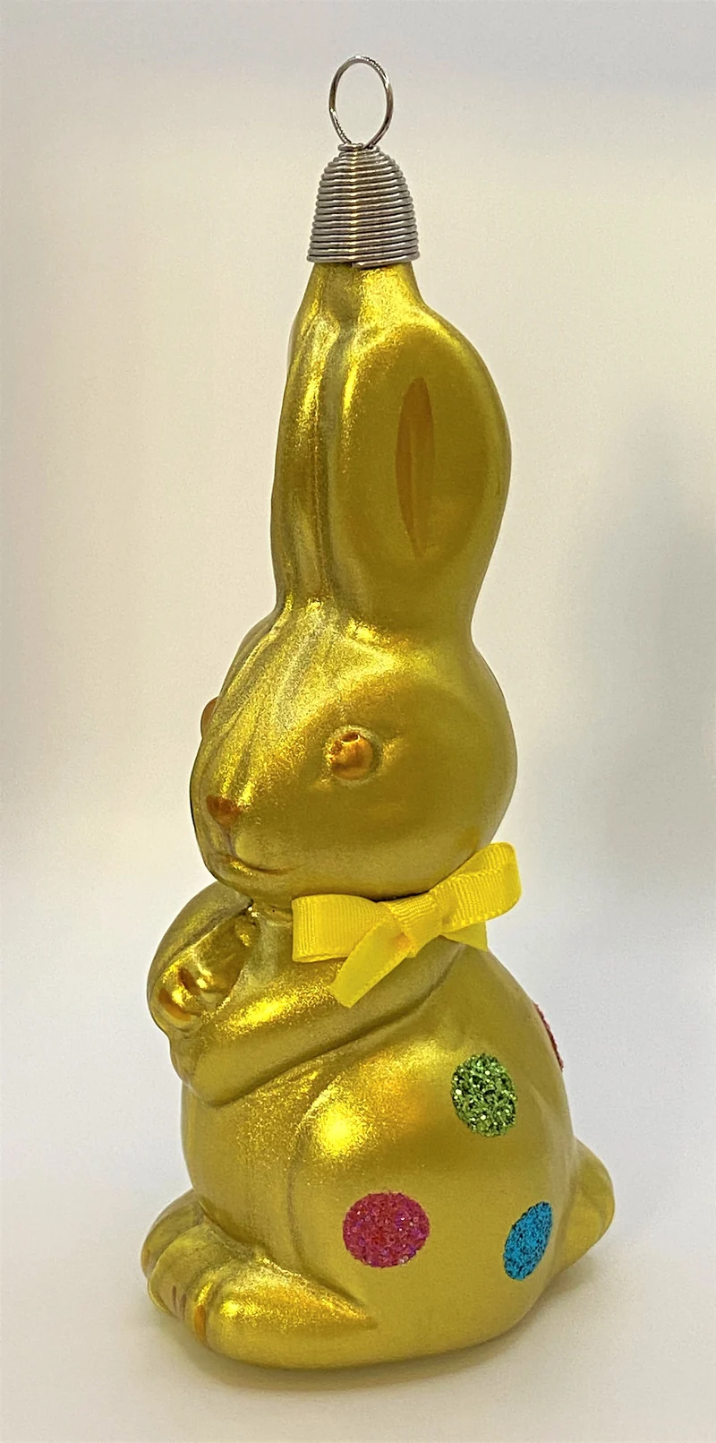 Olivgrüner Osterhase mit bunten Tupfen