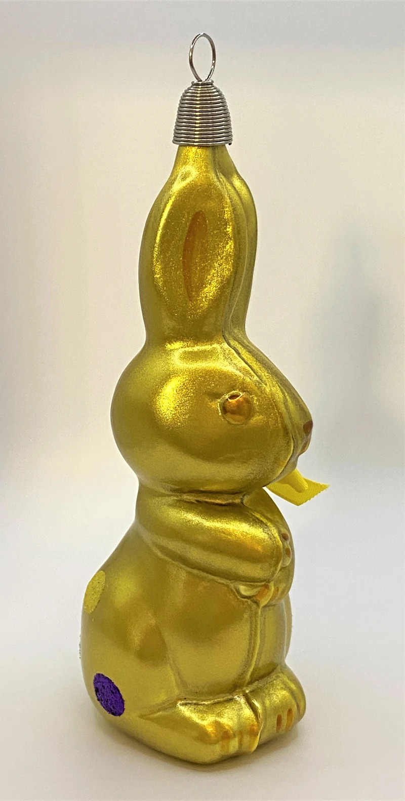 Olivgrüner Osterhase mit bunten Tupfen
