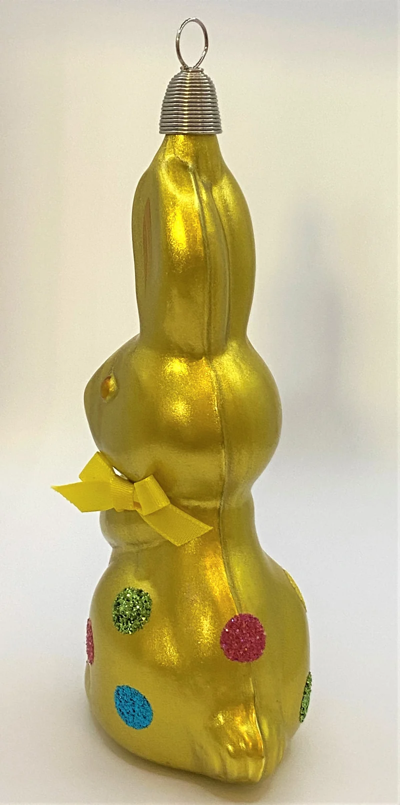 Olivgrüner Osterhase mit bunten Tupfen