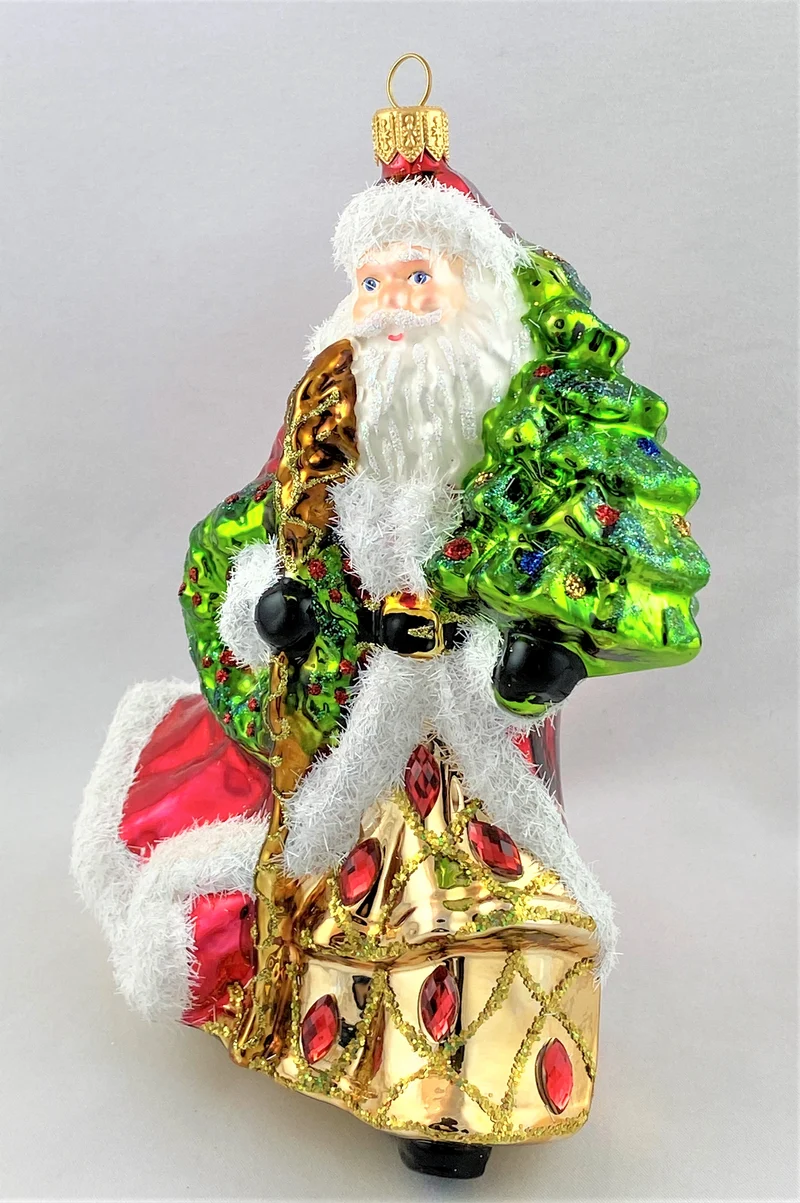 Der Weihnachtsmann im edlen Gewand bringt den Christbaum
