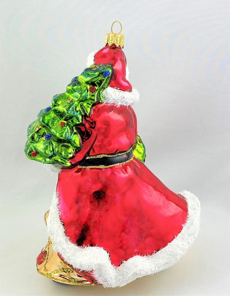 Der Weihnachtsmann im edlen Gewand bringt den Christbaum