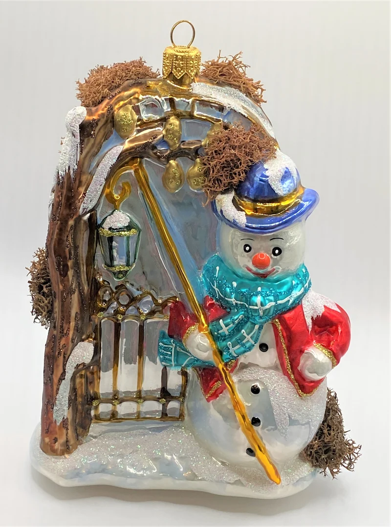 Der Schneemann leuchtet mit der Laterne am Gartentor