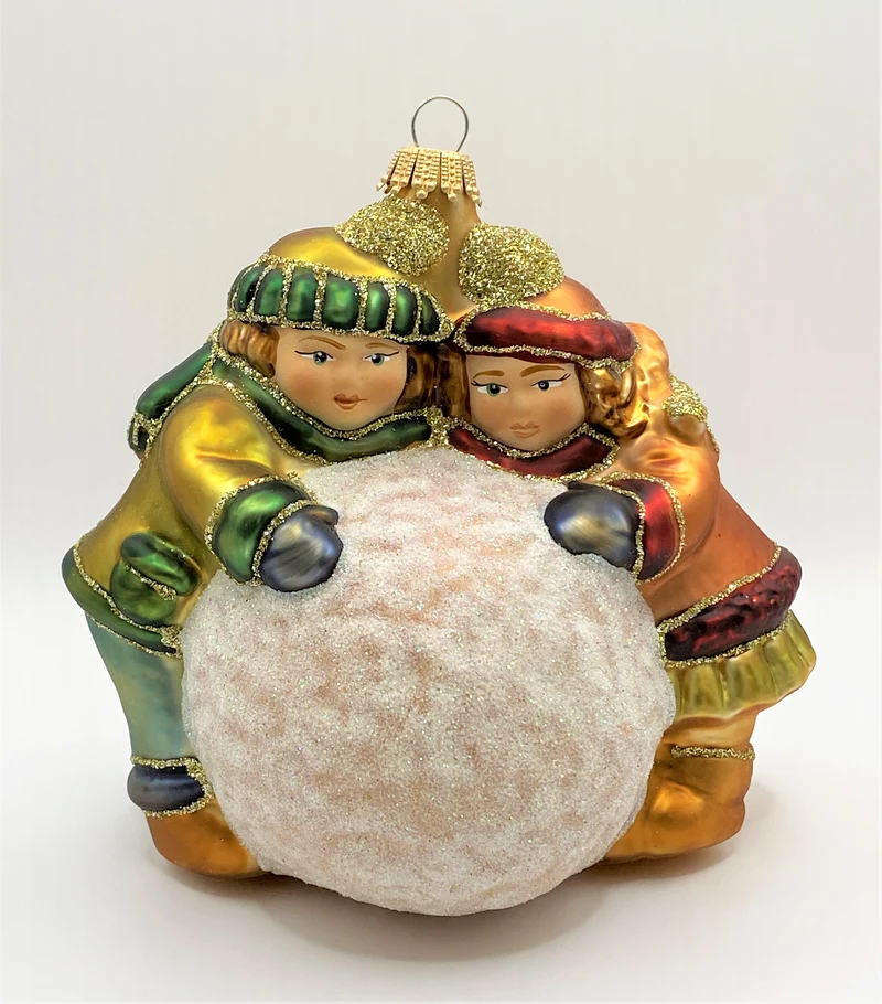 Zwei Kinder rollen einen grossen Schneeball