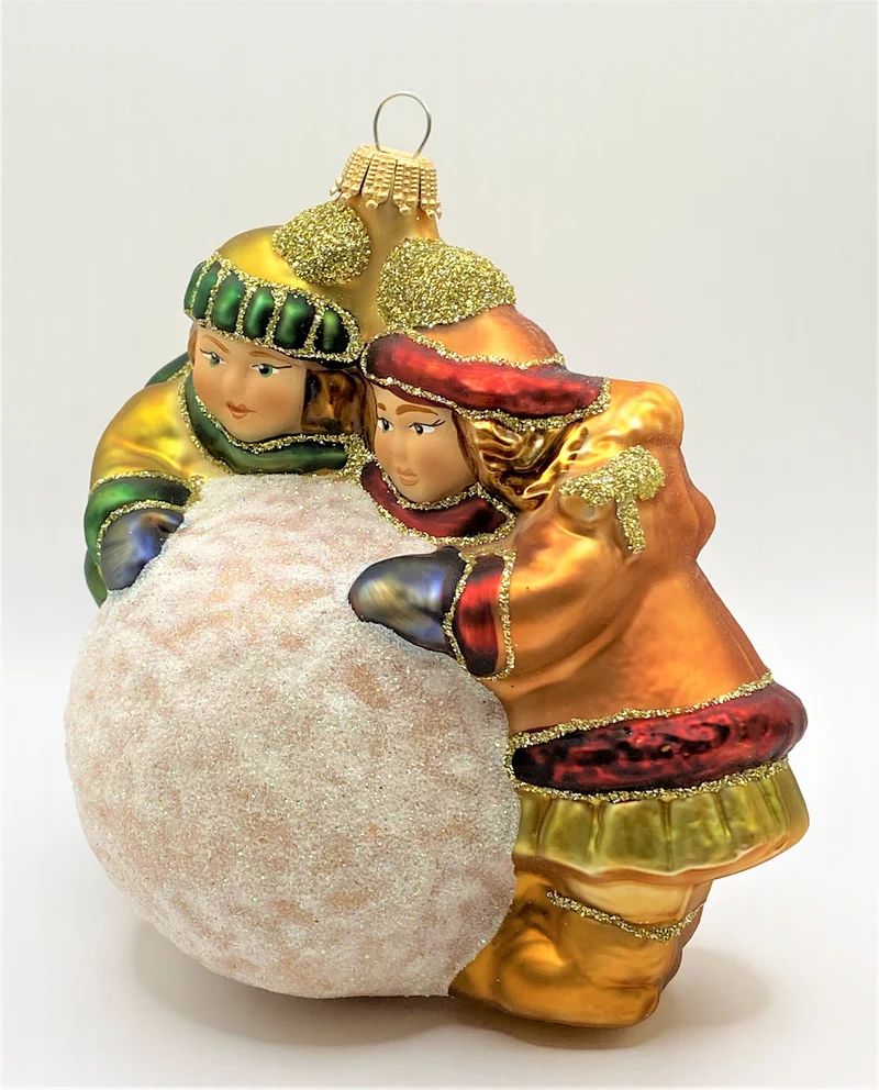 Zwei Kinder rollen einen grossen Schneeball
