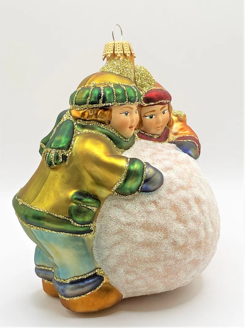 Zwei Kinder rollen einen grossen Schneeball