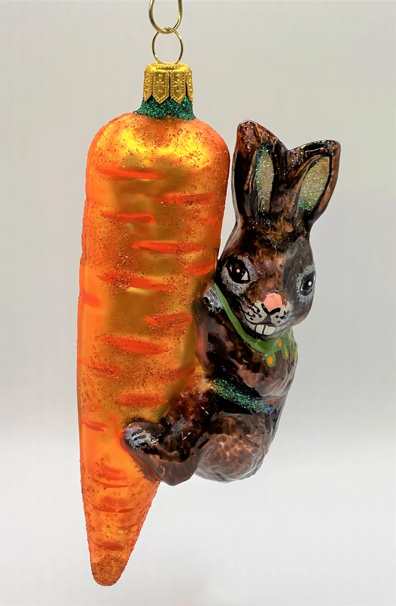 Brauner Osterhase klettert an der Karotte