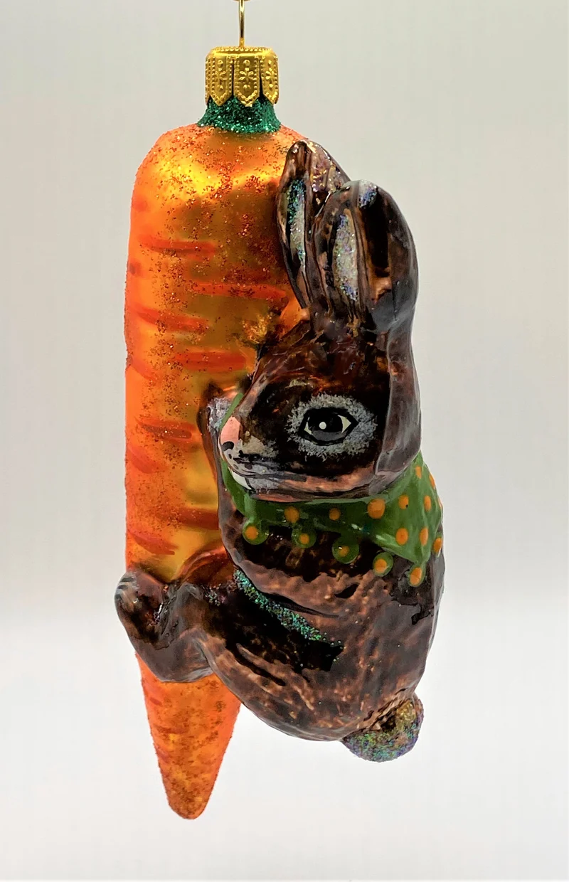 Brauner Osterhase klettert an der Karotte