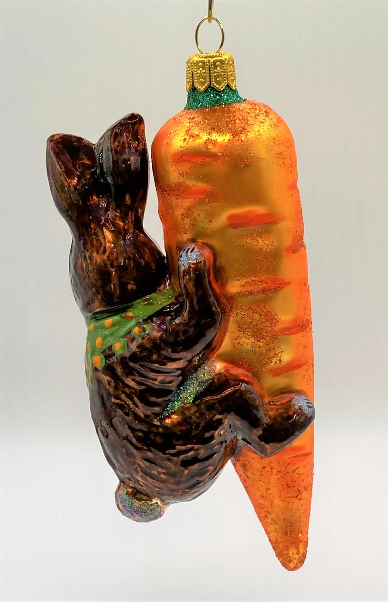 Brauner Osterhase klettert an der Karotte