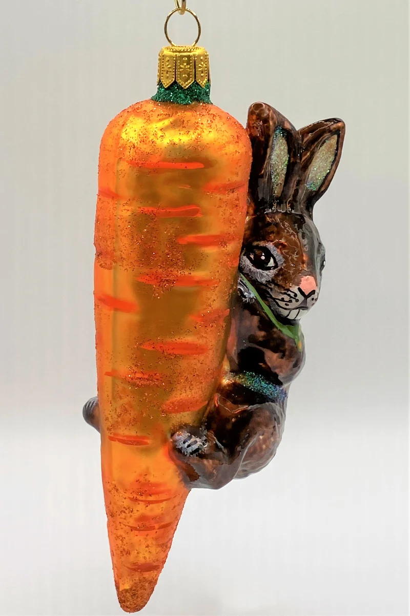 Brauner Osterhase klettert an der Karotte