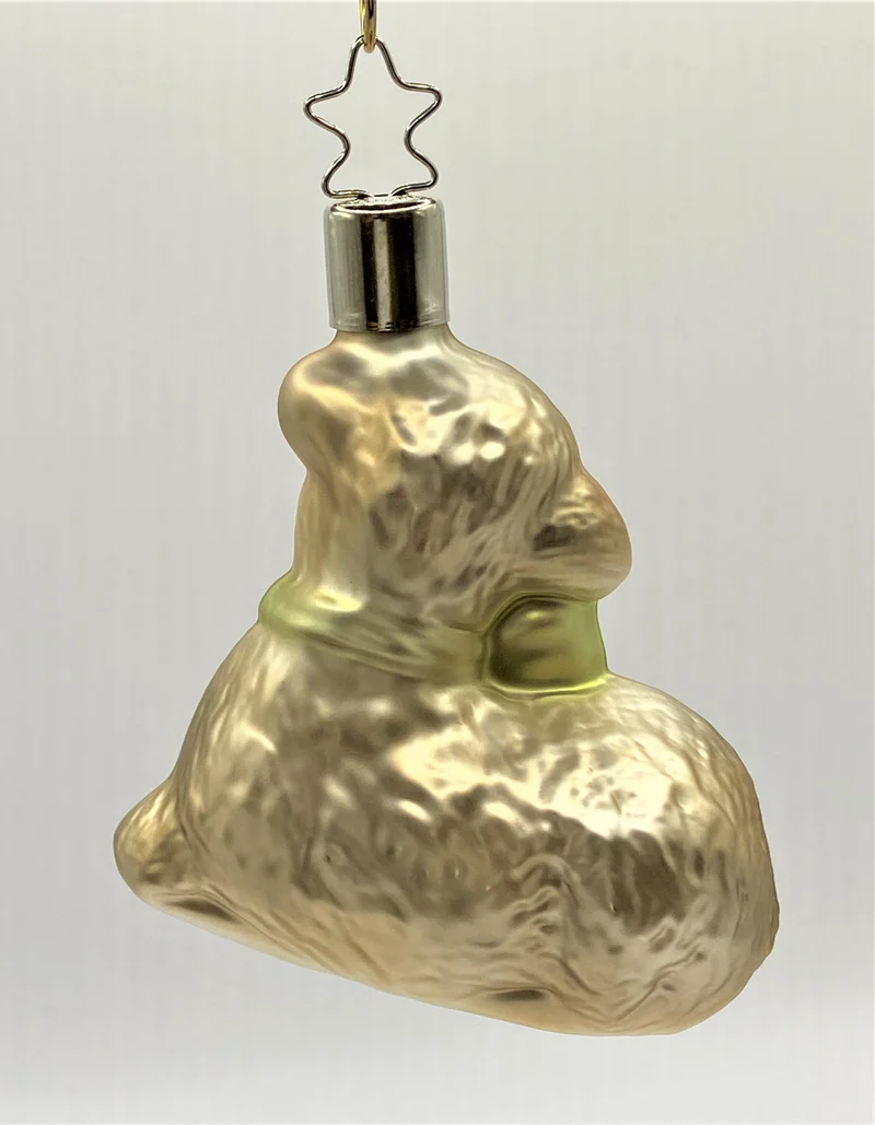 Liegendes Oster-Lämmchen mit grüner Schleife